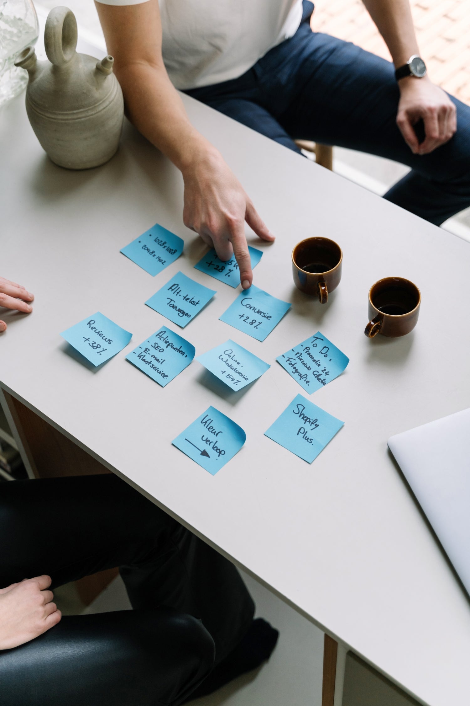 De WBshopmaker wijzend naar blauwe post-its voor optimalisatie van webshop