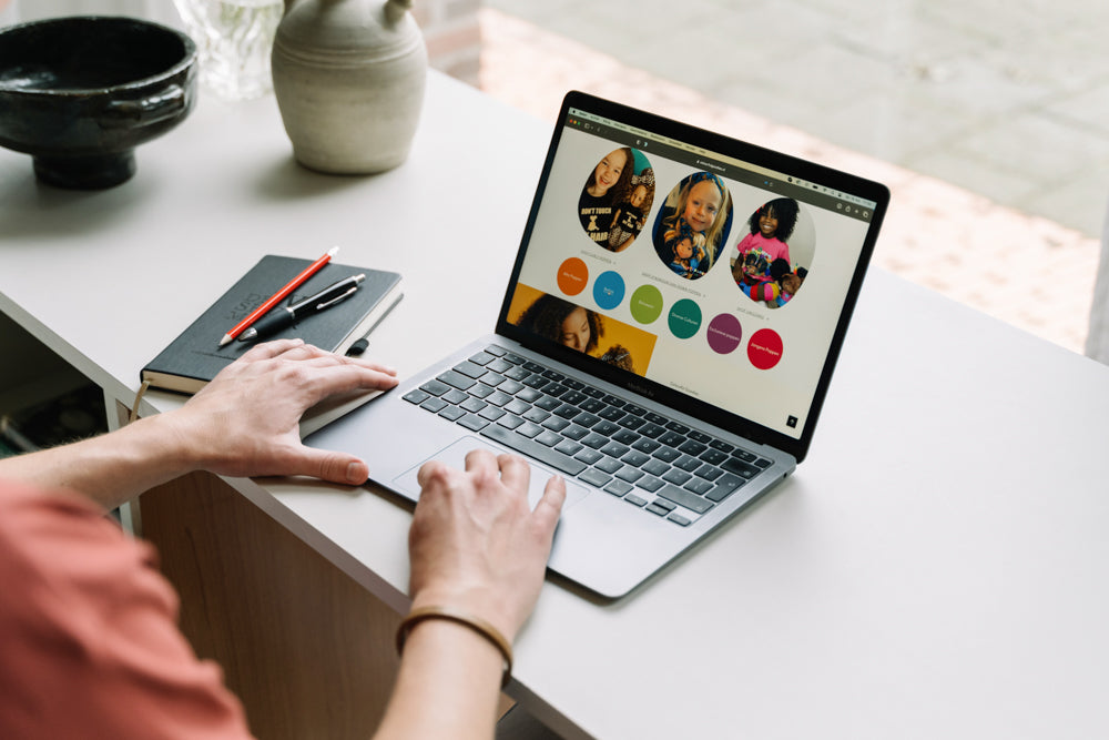 De WBshopmaker kijkend naar zijn MacBook 