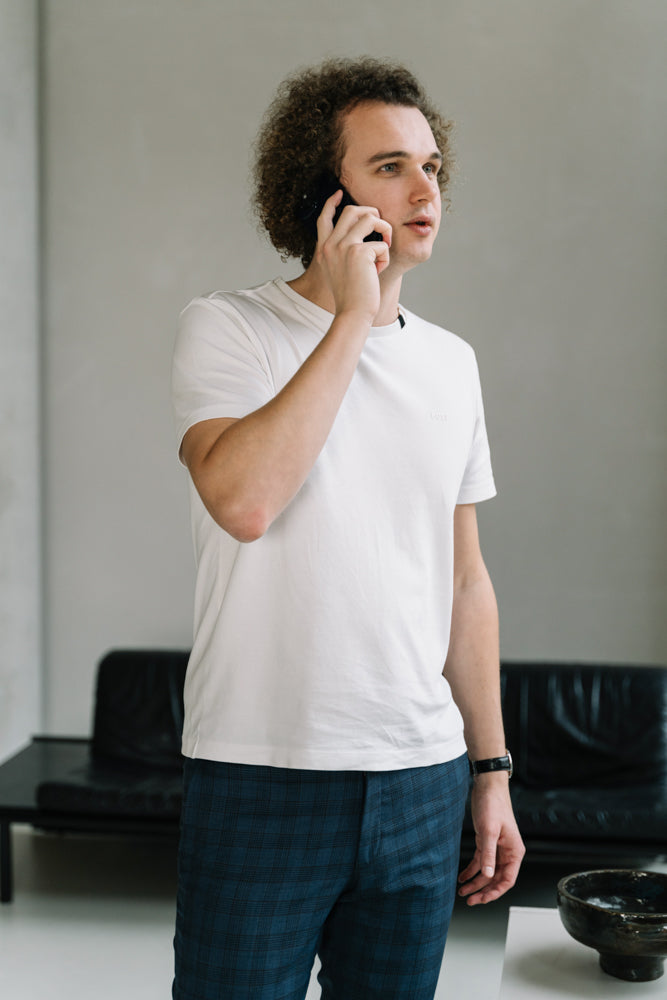 De WBshopmaker met een iPhone in handen bellend met klant